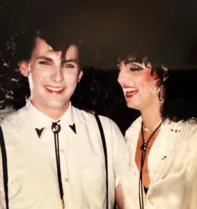 Smiling couple in vintage clothing, 1980s style.