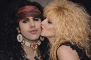 Person kissing another with big hairstyle.