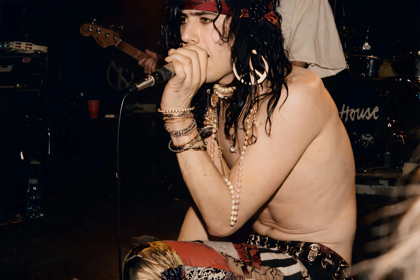 Young man passionately singing into a microphone at a live performance.