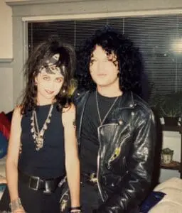 Two people in punk rock outfits, indoors.