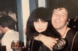 Couple embracing at a party, smiling together.