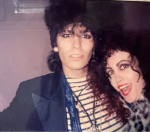 Two people posing with 1980s fashion.