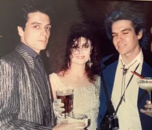 Three people at a party with drinks.