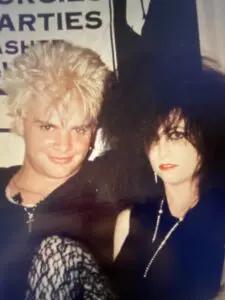 Two people with punk hairstyles and makeup.
