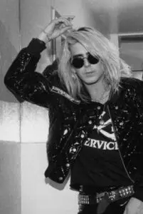 Person in sunglasses and leather jacket posing.
