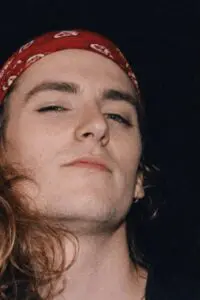 Close-up of a person with long hair and a red bandana.