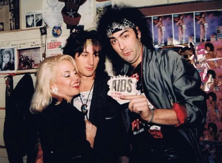 Three people holding "AIDS" sign in store.