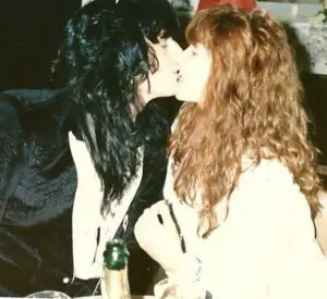 Couple kissing at a table, intimate moment.