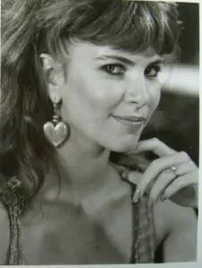 Smiling woman with heart-shaped earring.