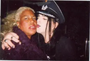 Two people close together, one wearing cap