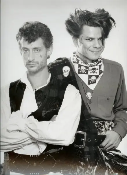 Two men in pirate-inspired costumes smiling