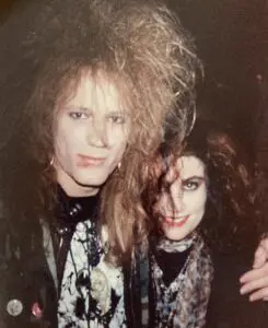 Two people with teased hair and heavy makeup
