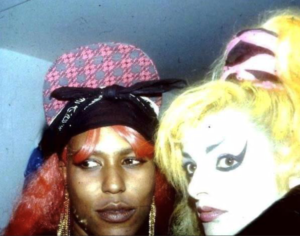 Two people in colorful wigs and makeup