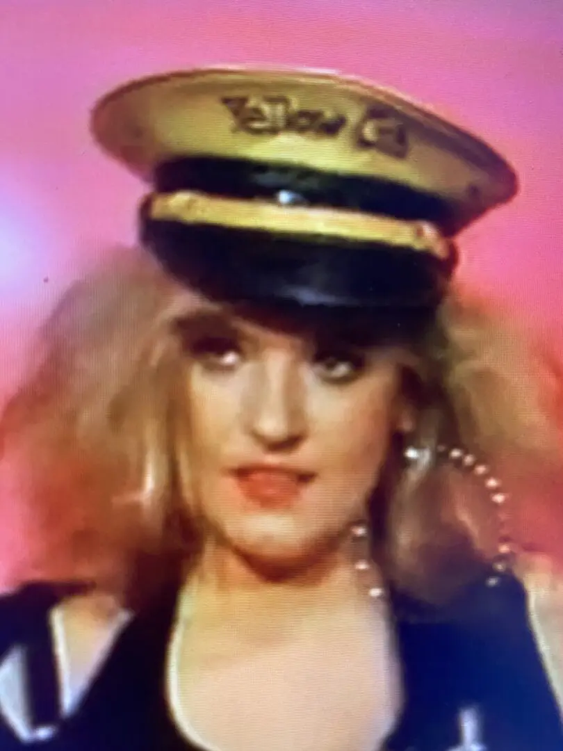 Blonde person wearing gold and black captain hat