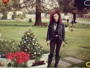 Person in leather jacket by decorated Christmas tree